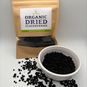 A bowl of dried elderberries next to an organic bag.