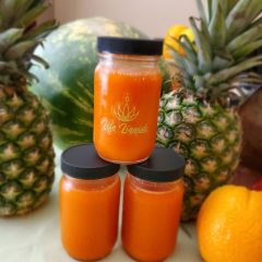 A stack of three jars with orange juice.