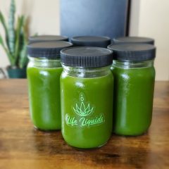 A group of green jars sitting on top of a wooden table.